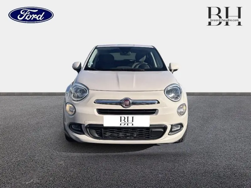 Vue avant d'une FIAT 500X argentée de 2015 avec phares ronds et calandre chromée distinctive.