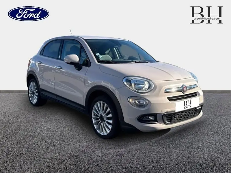 Vue 3/4 avant droit d'une FIAT 500X argentée de 2015 avec jantes alu et boucliers couleur carrosserie.