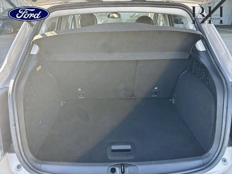 Coffre ouvert vu de l'arrière d'une FIAT 500X argentée, montrant l'espace de chargement et la tablette cache-bagages.