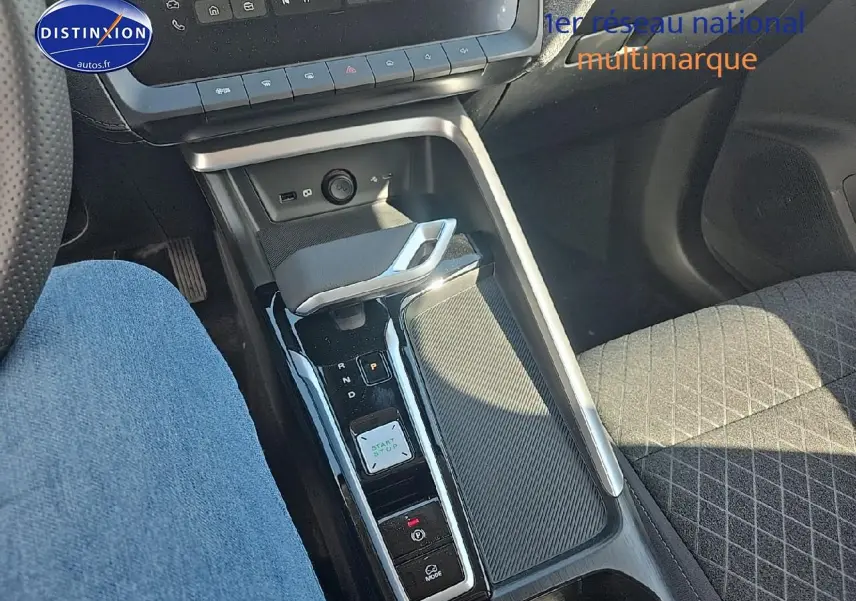 Vue intérieure centrée sur la console centrale et levier de vitesse automatique du MG ZS Hybrid noir, avec siège tissu gris.