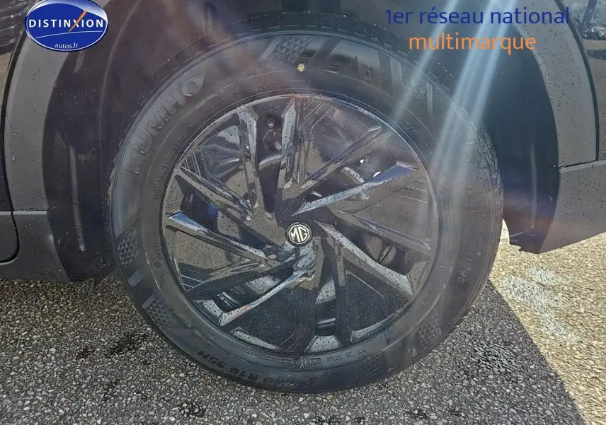 Gros plan sur la roue avant gauche noire du MG ZS Hybrid 197 avec jante acier noire à motifs aérodynamiques.