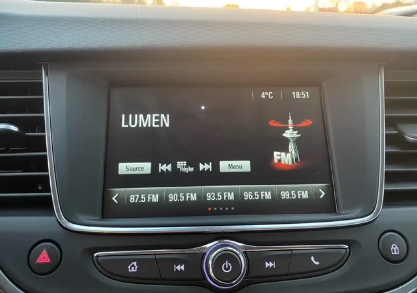 Vue rapprochée de l’écran multimédia central de l’Opel Crossland gris magnetic affichant la radio FM et la température extérieure.