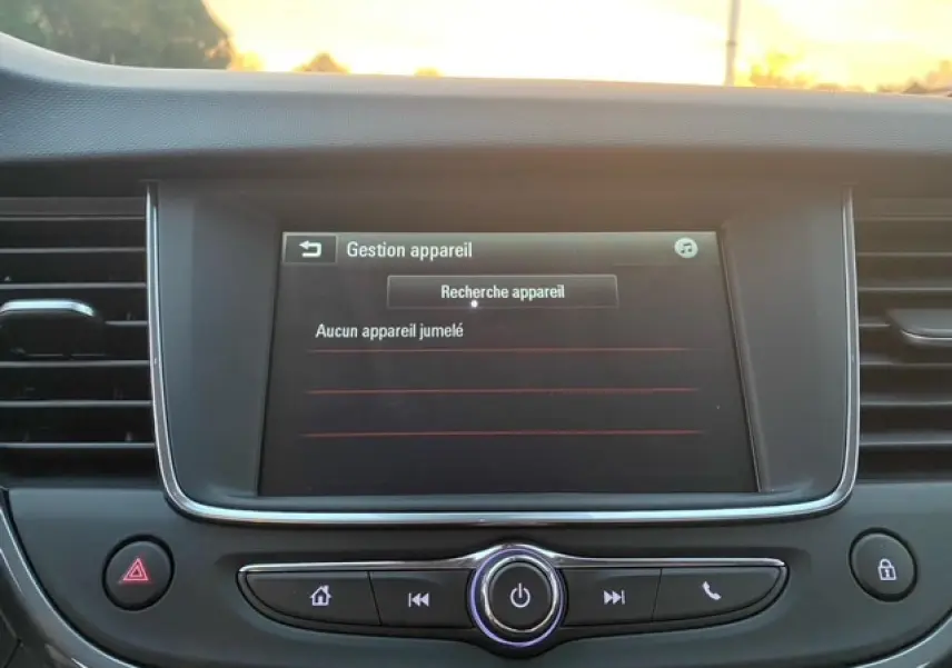 Écran tactile central de l’Opel Crossland 2022 affichant la gestion des appareils en mode recherche, entouré de commandes noires.