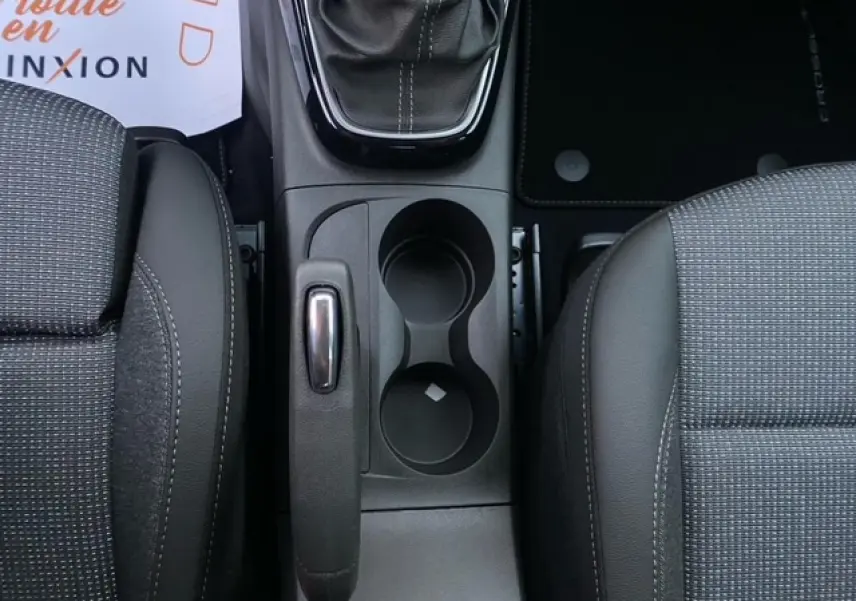 Vue plongeante sur la console centrale intérieure de l'Opel Crossland gris Magnetic, montrant levier de vitesse et porte-gobelets.