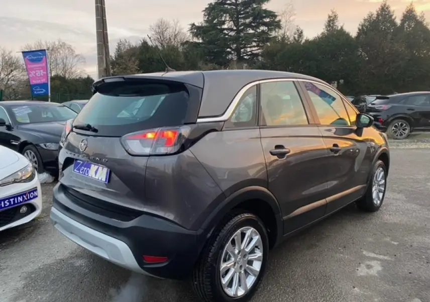 Vue 3/4 arrière droite d'un Opel Crossland gris magnetic 2022 avec jantes alliage 16'' et vitres surteintées.