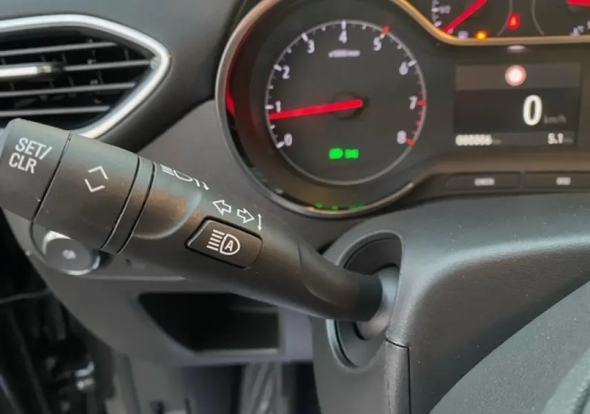 Gros plan sur le commodo gauche et le tableau de bord digital d’un Opel Crossland gris Magnetic, version 2022.