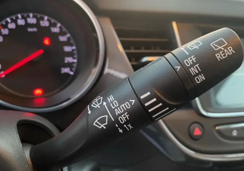 Gros plan sur la commande des essuie-glaces de l’Opel Crossland 2022, avec tableau de bord et écran tactile en arrière-plan.