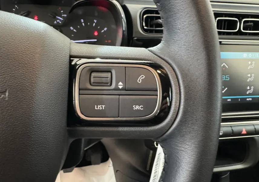 Gros plan sur le volant cuir noir de la Citroën C3 2020, avec commandes multifonctions et tableau de bord partiel visible.
