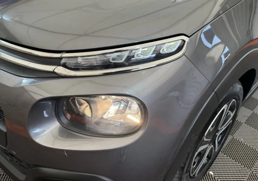 Gros plan sur l’avant droit gris foncé de la Citroën C3 2020, mettant en valeur ses phares LED et sa jante au design distinctif.
