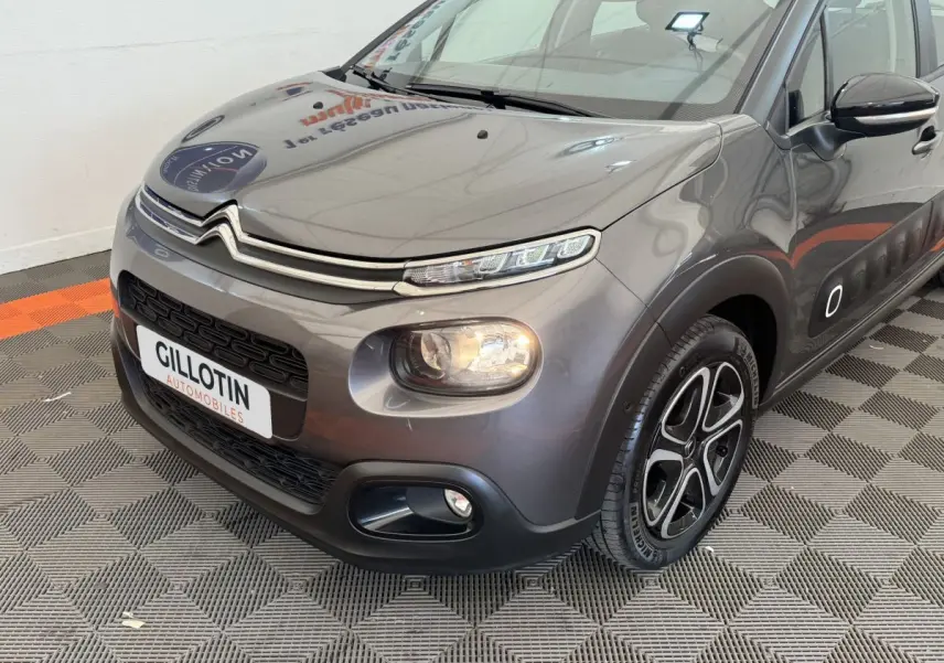 Citroën C3 gris foncé vue 3/4 avant droit, avec phares LED et jantes alliage distinctives.