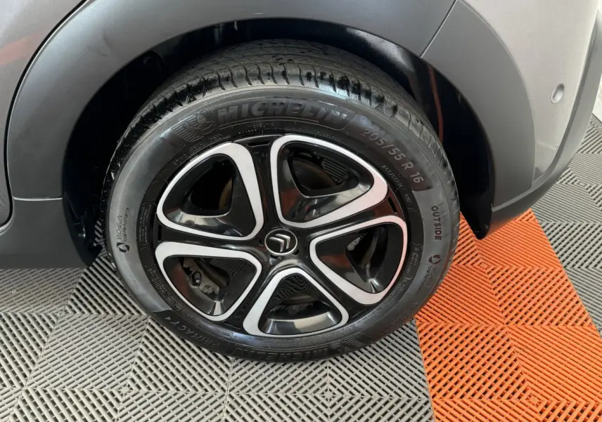 Gros plan sur la roue arrière droite gris foncé d'une Citroën C3 2020 avec jante alliage noire et argentée distinctive.