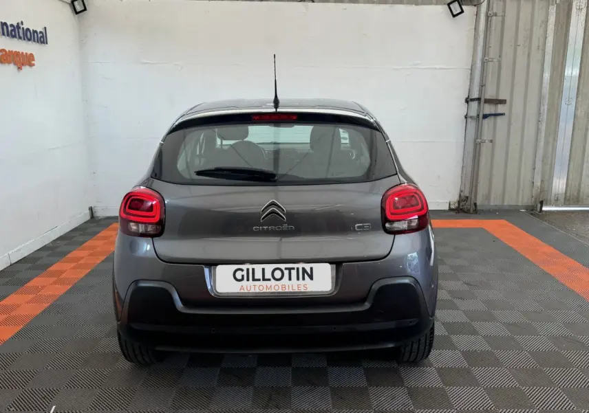 Vue arrière d'une Citroën C3 gris foncé 2020 avec feux LED et logo centré sur un sol à damier noir et orange.