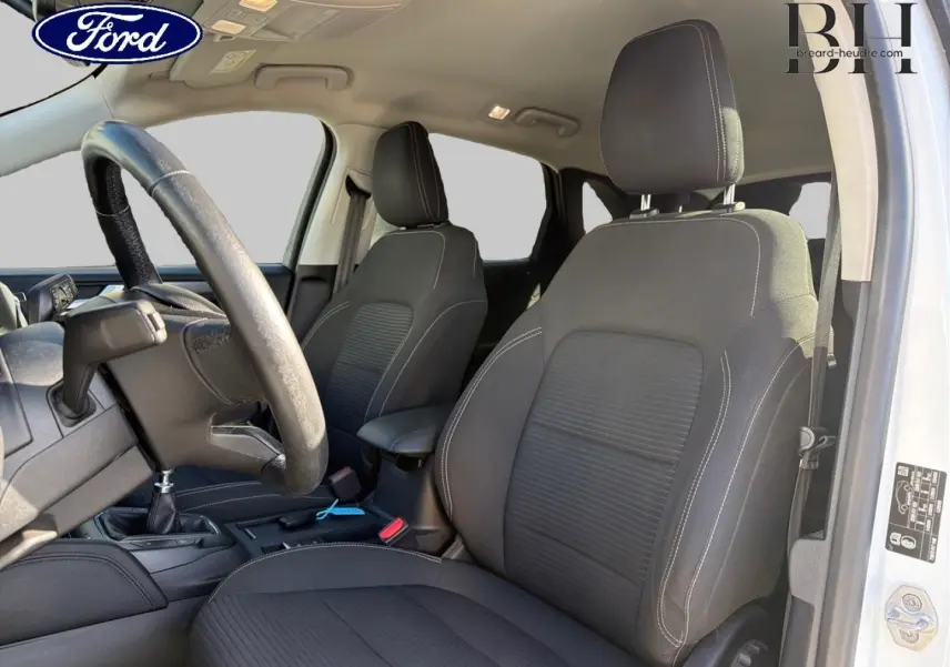 Vue intérieure côté conducteur du Ford Kuga blanc Glacier 2021, sièges sport noirs avec coutures contrastantes.