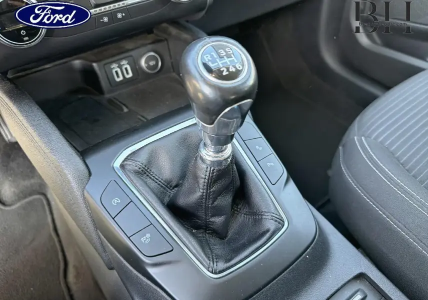 Gros plan sur le levier de vitesses manuel noir de la Ford Kuga 1.5 EcoBlue 2021 avec sellerie tissu gris.