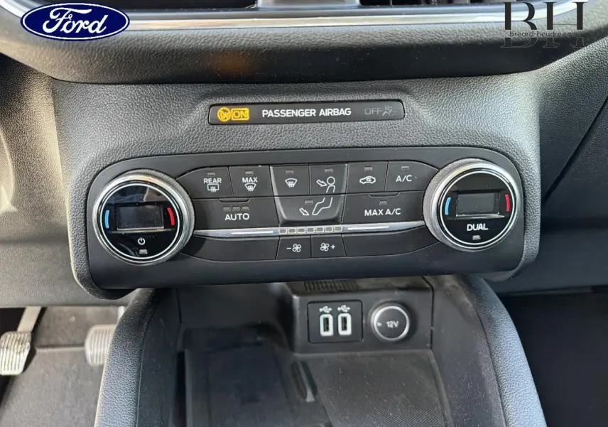 Vue rapprochée de la console centrale du Ford Kuga 2021, montrant la climatisation bi-zone et les ports USB avec prise 12V.