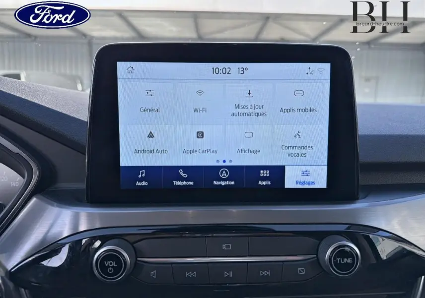 Vue rapprochée de l’écran tactile central et de la console noire brillante du Ford Kuga blanc Glacier 2021.