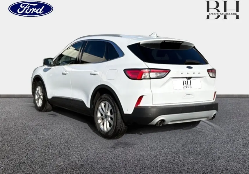 Vue 3/4 arrière droite d'un Ford Kuga blanc Glacier avec vitres arrière surteintées et double sortie d'échappement.
