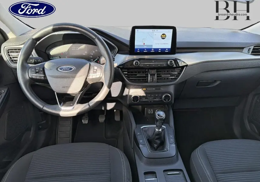 Vue intérieure frontale du Ford Kuga 1.5 EcoBlue 2021, montrant le volant cuir multifonction et la console centrale avec écran tactile.