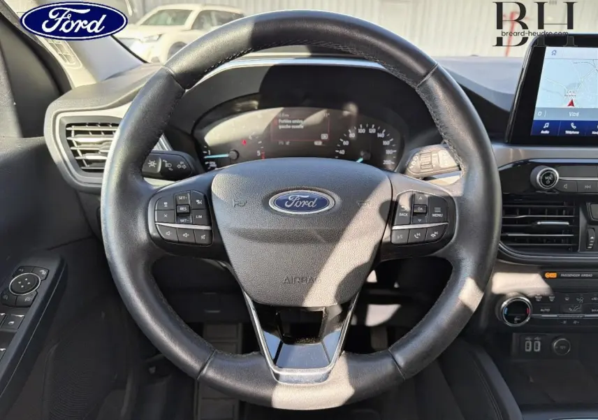 Vue intérieure centrée sur le volant cuir multifonction du Ford Kuga 1.5 EcoBlue 2021 avec tableau de bord et écran tactile.