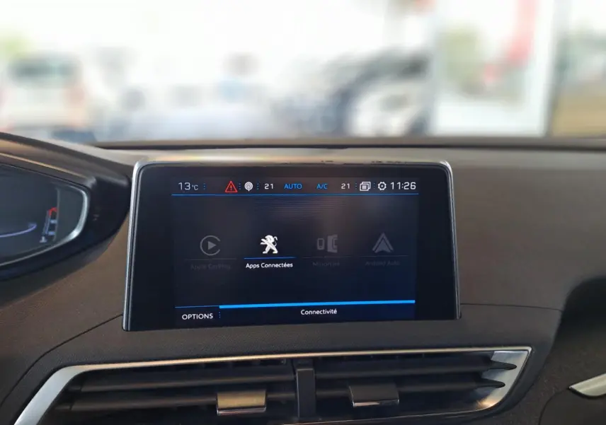 Écran central tactile du tableau de bord d'une Peugeot 3008 gris Artense, affichant les apps connectées.