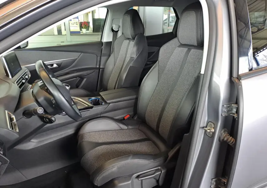Vue intérieure côté conducteur du Peugeot 3008 gris Artense 2019, sièges en cuir et tissu gris avec console centrale moderne.