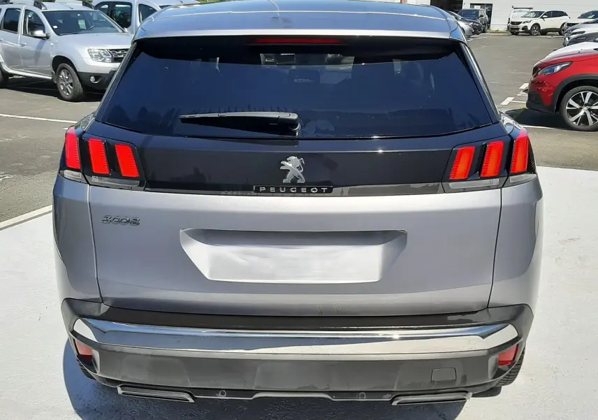 Vue arrière d'un Peugeot 3008 gris Artense avec feux arrière à trois griffes rouges et lunette arrière teintée.