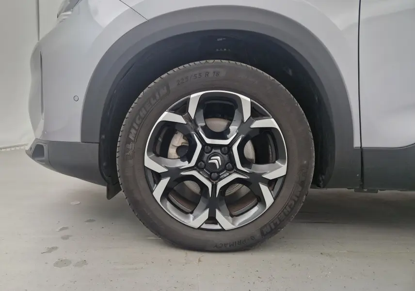 Gros plan sur la roue avant gauche du Citroën C5 Aircross 2024 gris Artense avec jante alliage noire et argentée.