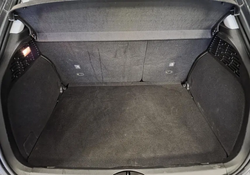 Coffre ouvert vu de dessus du Fiat 500X gris, montrant un espace de chargement propre et bien éclairé.