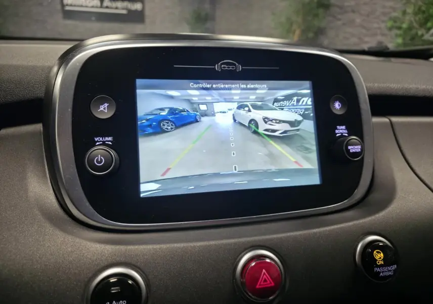 Écran central montrant la caméra de recul du Fiat 500X gris, vue arrière en intérieur de garage.