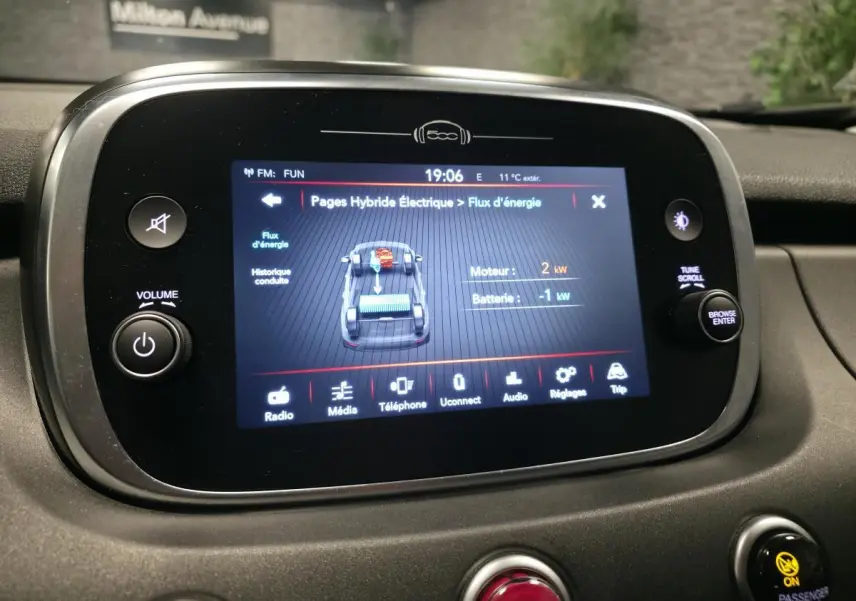 Écran tactile central affichant le flux d'énergie du système hybride dans l'habitacle du Fiat 500X gris, vue intérieure.