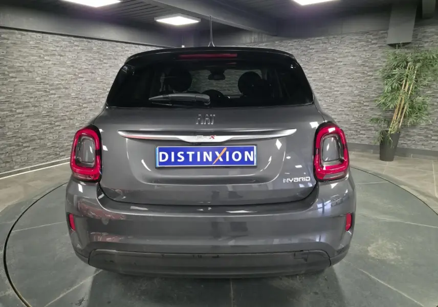 Vue arrière d'une Fiat 500X gris métallisé 2024 avec feux arrière LED et logo Hybrid visible.