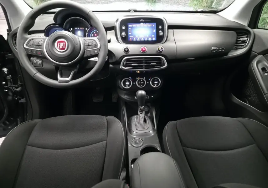 Intérieur noir de la Fiat 500X 2024 vu de face, avec tableau de bord gris titane et écran tactile central.