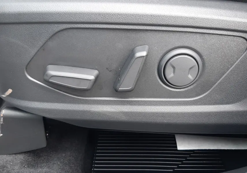 Gros plan sur les commandes de réglage électrique du siège côté conducteur du Hyundai Tucson 2025 gris Ecotronic.