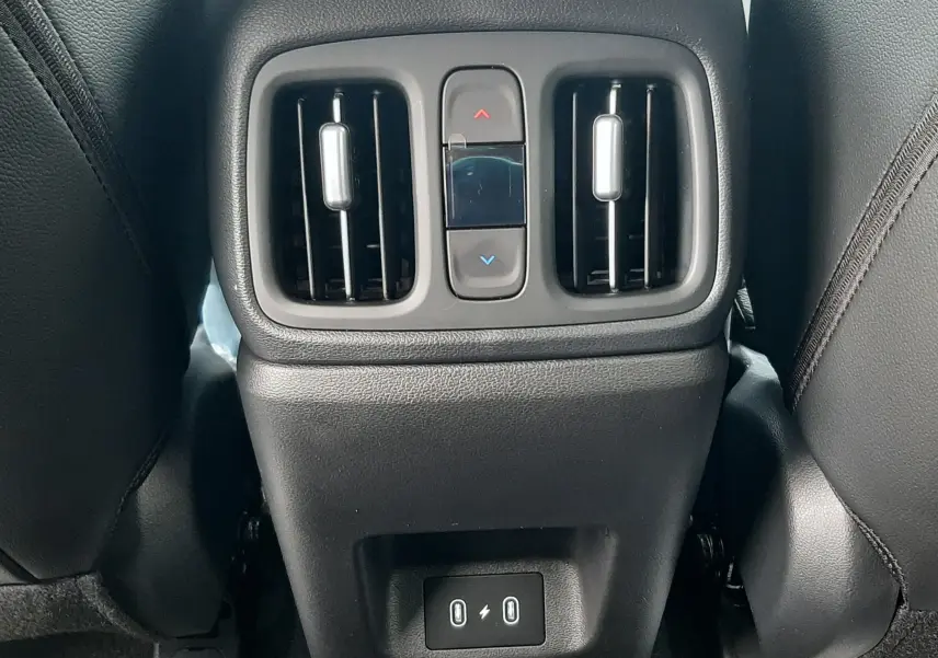 Vue rapprochée de la console arrière noire du Hyundai Tucson 2025, avec bouches d'aération et ports USB visibles.