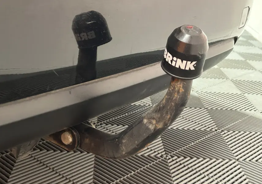 Gros plan sur l'attelage Brink fixé à l'arrière noir d'une Peugeot 308 SW, avec reflet sur le pare-chocs.