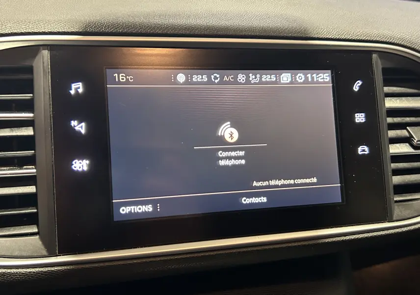 Écran tactile central du tableau de bord de la Peugeot 308 SW noir, affichant la connexion Bluetooth téléphone.