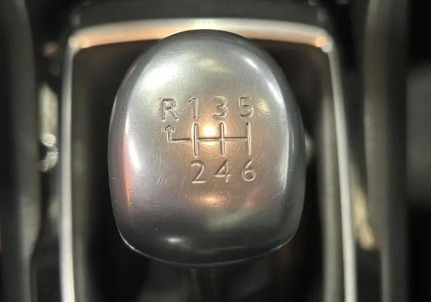 Gros plan sur le pommeau de la boîte manuelle 6 vitesses d'une Peugeot 308 SW noire, montrant le schéma des rapports.