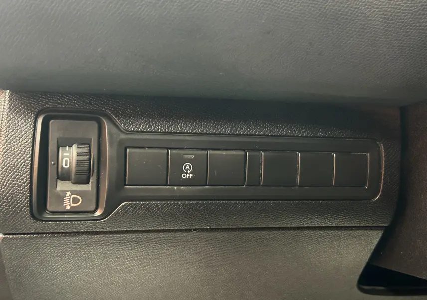 Détail de la console intérieure noire du Peugeot 308 SW 2018, montrant les boutons de réglage des phares et de désactivation du système start-stop.