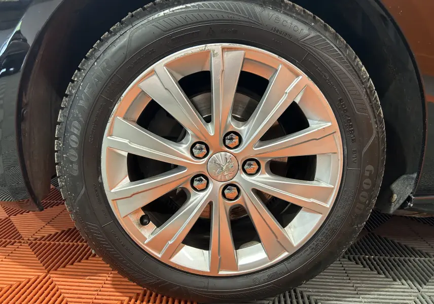 Gros plan sur la jante alliage argentée et le pneu Goodyear d’une Peugeot 308 SW noire, côté droit.