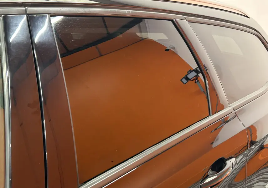 Vue latérale droite rapprochée d’une Peugeot 308 SW noire, mettant en valeur la vitre arrière teintée et la poignée de porte.