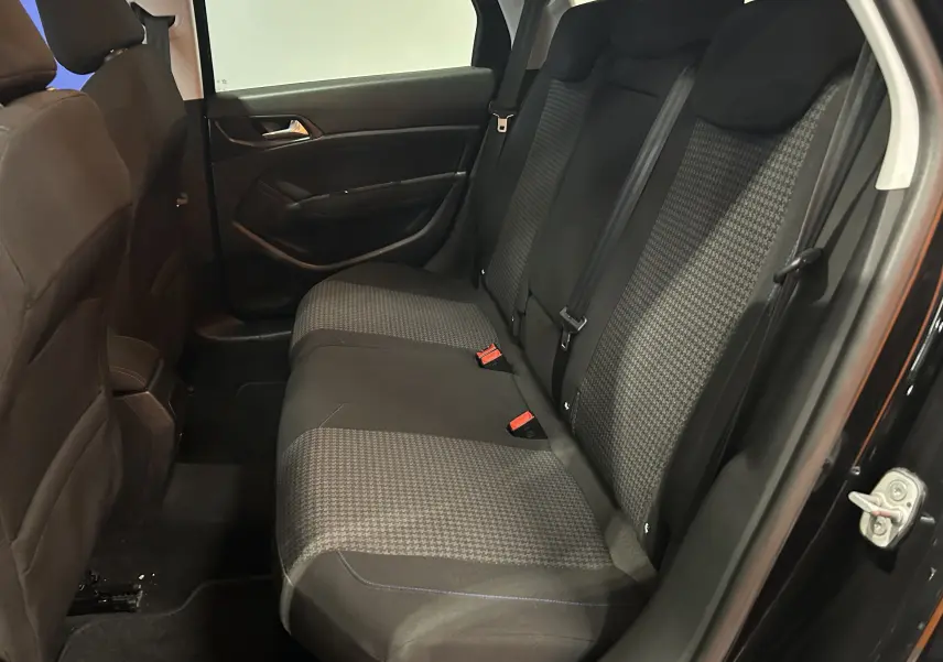 Vue intérieure côté droit des sièges arrière en tissu gris et noir d'une Peugeot 308 SW noire de 2018.
