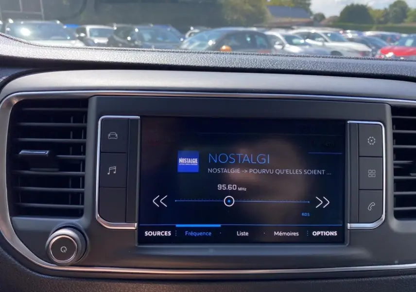 Écran tactile central du Peugeot Expert Fourgon 2022 affichant la radio Nostalgie, entouré de commandes noires et grises.