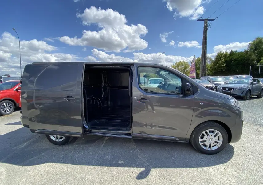 Peugeot Expert Fourgon gris platinium vu de profil gauche avec porte latérale coulissante ouverte montrant l'intérieur vide.