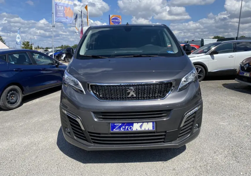 Vue avant d'un Peugeot Expert Fourgon gris platinium avec calandre noire et plaque d'immatriculation Zero KM visible.