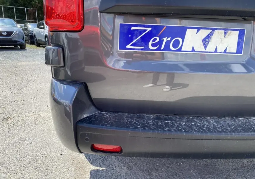 Vue rapprochée de l'arrière droit du Peugeot Expert Fourgon gris platinium avec plaque Zéro KM visible.