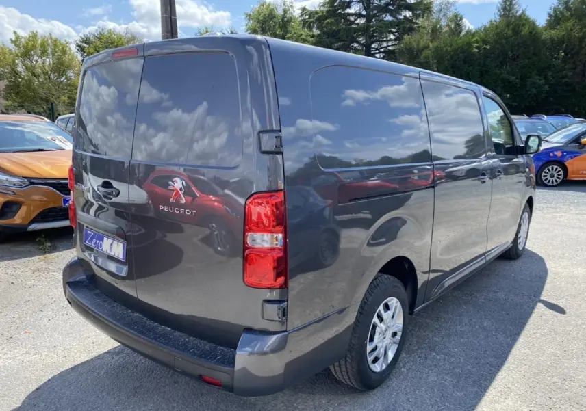 Vue 3/4 arrière droite d’un Peugeot Expert Fourgon gris platinium avec portes arrière battantes et porte latérale tôlée.