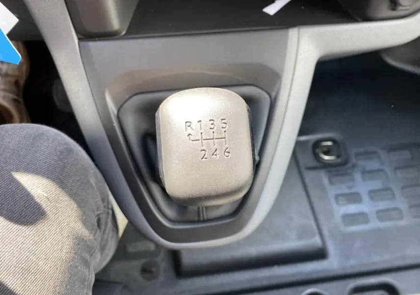 Le levier de vitesses manuel gris du Peugeot Expert Fourgon 2022 vu de dessus avec tapis caoutchouc noir.
