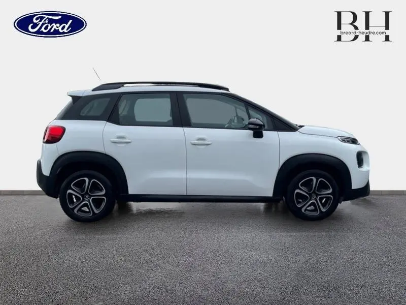 Vue latérale droite d'une Citroën C3 Aircross 2019 blanche avec barres de toit et jantes distinctives.