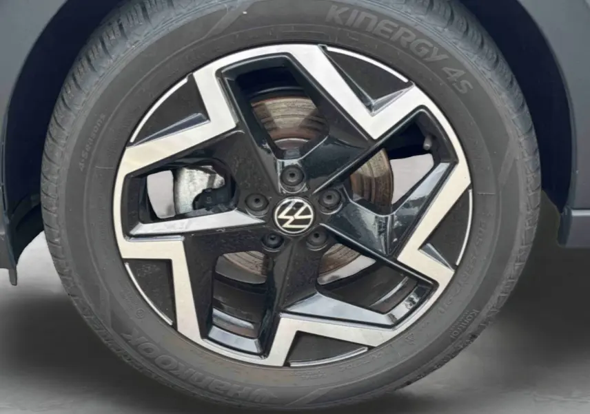 Gros plan sur la jante alliage noir et argentée 17 pouces du Volkswagen Taigo blanc, avec logo VW au centre.