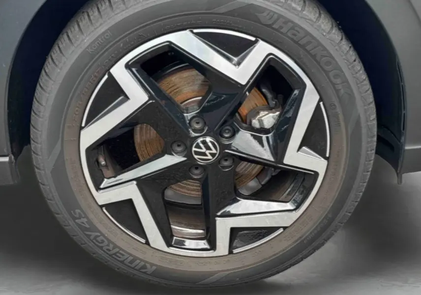 Gros plan sur la jante alliage noir et argentée de Volkswagen Taigo avec logo VW au centre et pneu Hankook.